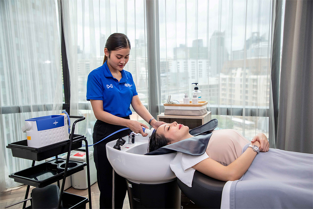 ผู้ชายกำลังเข้ารับการรักษาผมร่วงและผมบางด้วยเทคโนโลยีเลเซอร์ที่คลินิก